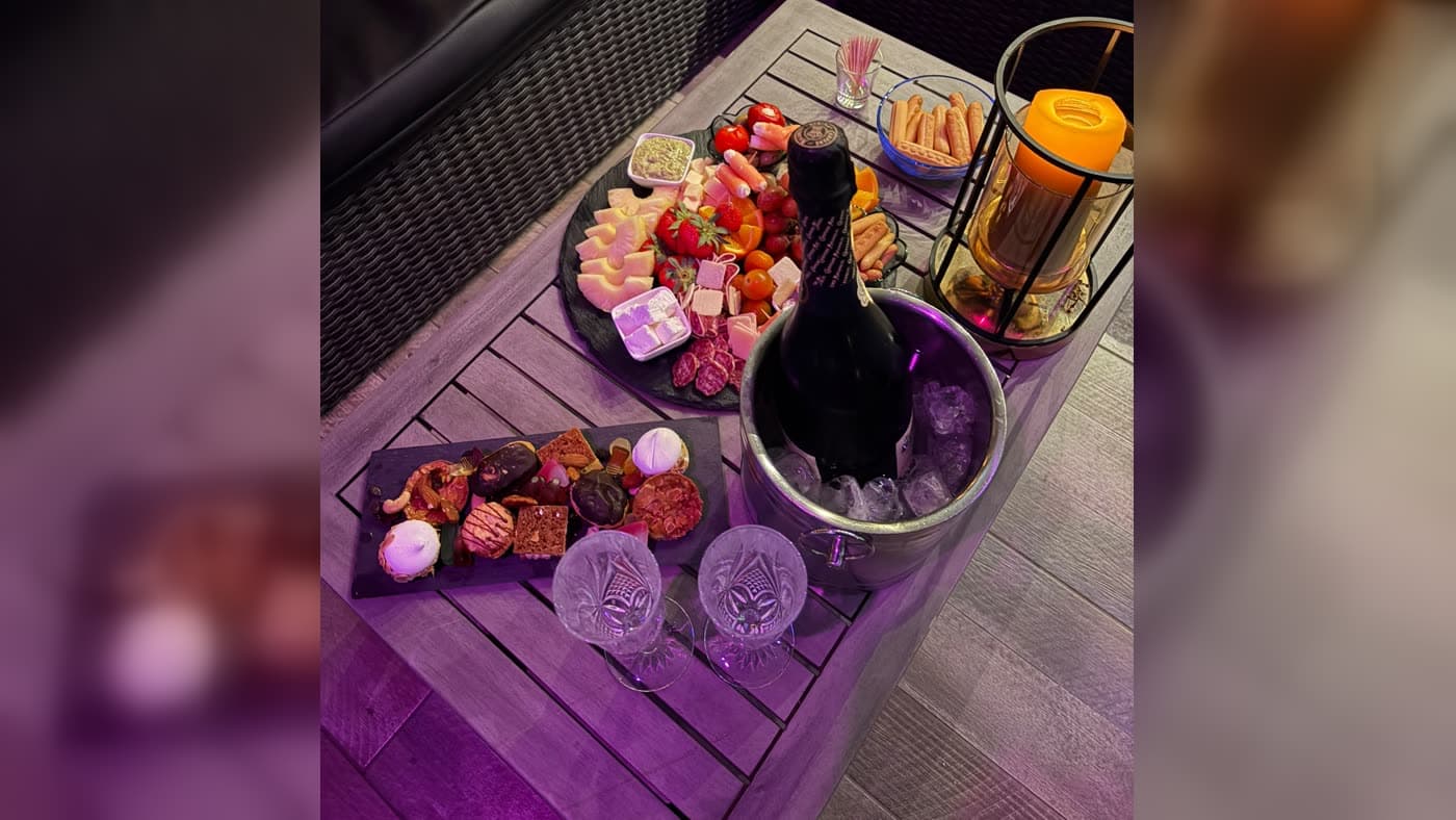 Charcuterie-kaasplank, champagne en twee glazen bij kaarslicht voor een avondje met z'n tweeën bij Aura Spa, privéspa nabij Brussel